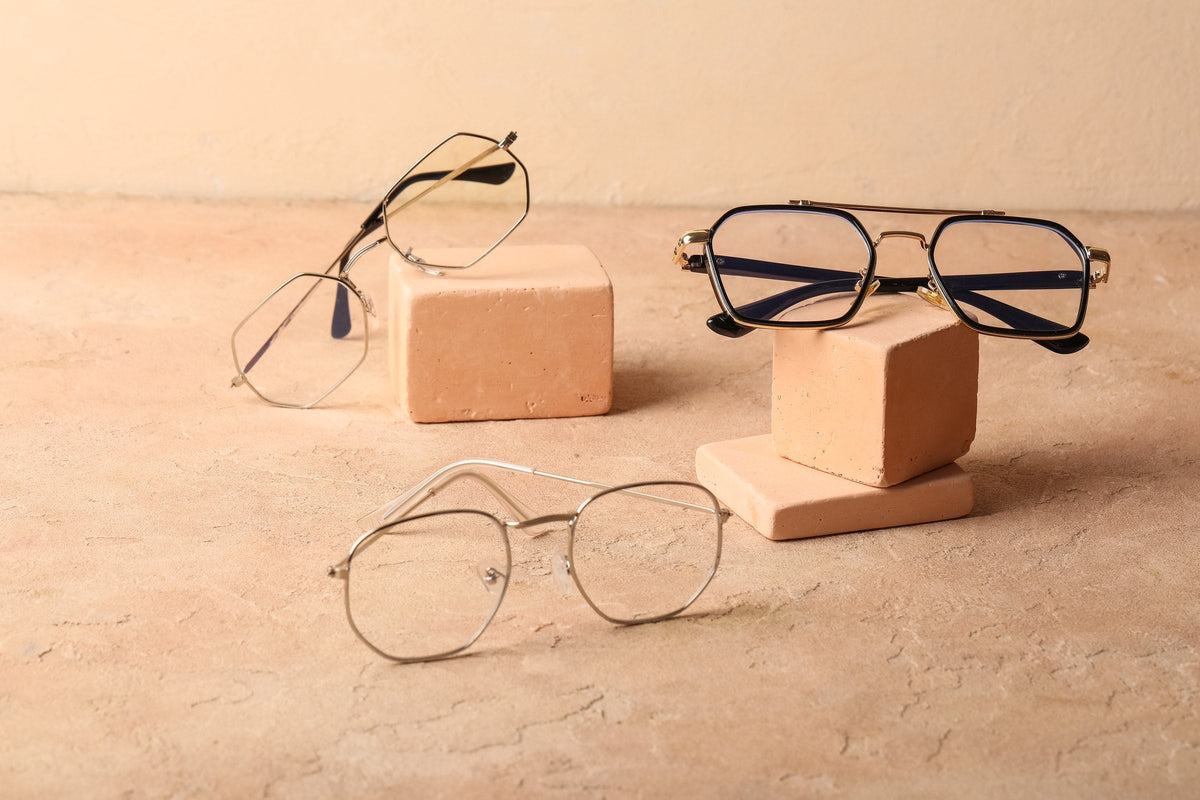 A collection of eyeglasses frames on a beige background