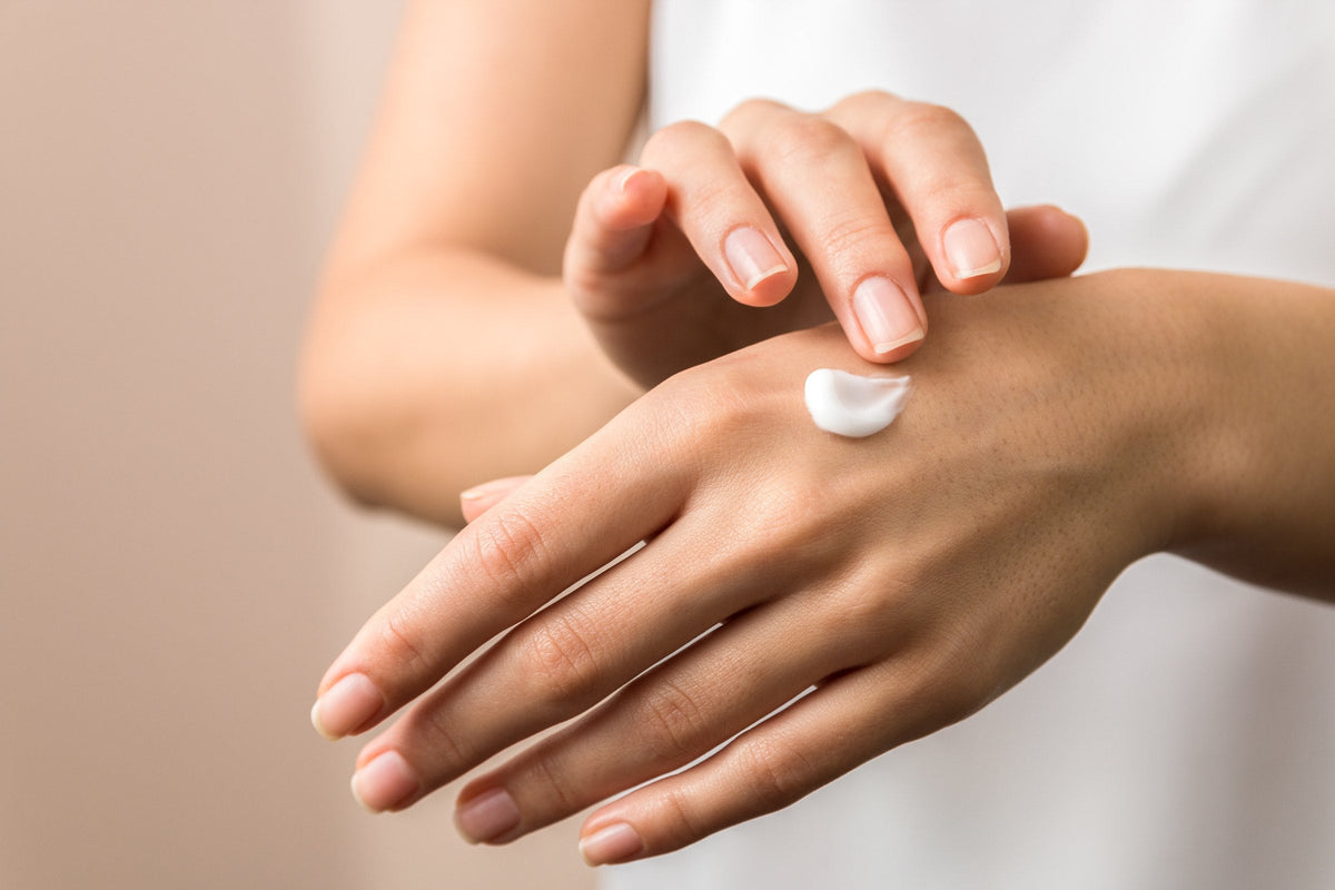 Hands smoothing in hand cream, close up