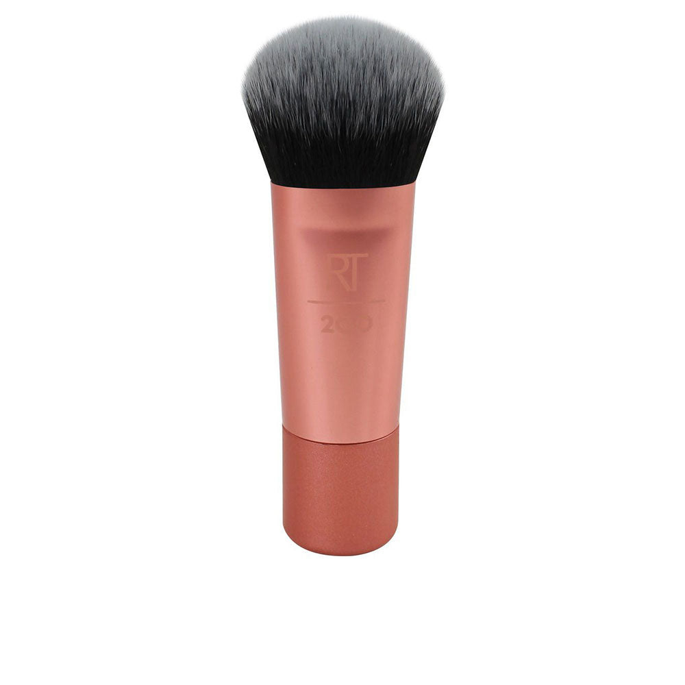 Compact rounded-flat synthetic face brush with short handle, travel-sized
