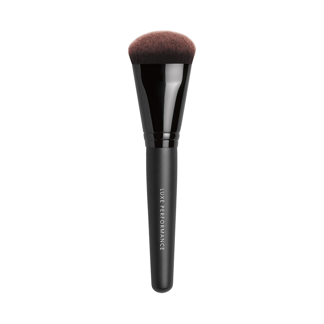Dense synthetic foundation brush with tapered fingertip-shaped head, wooden handle