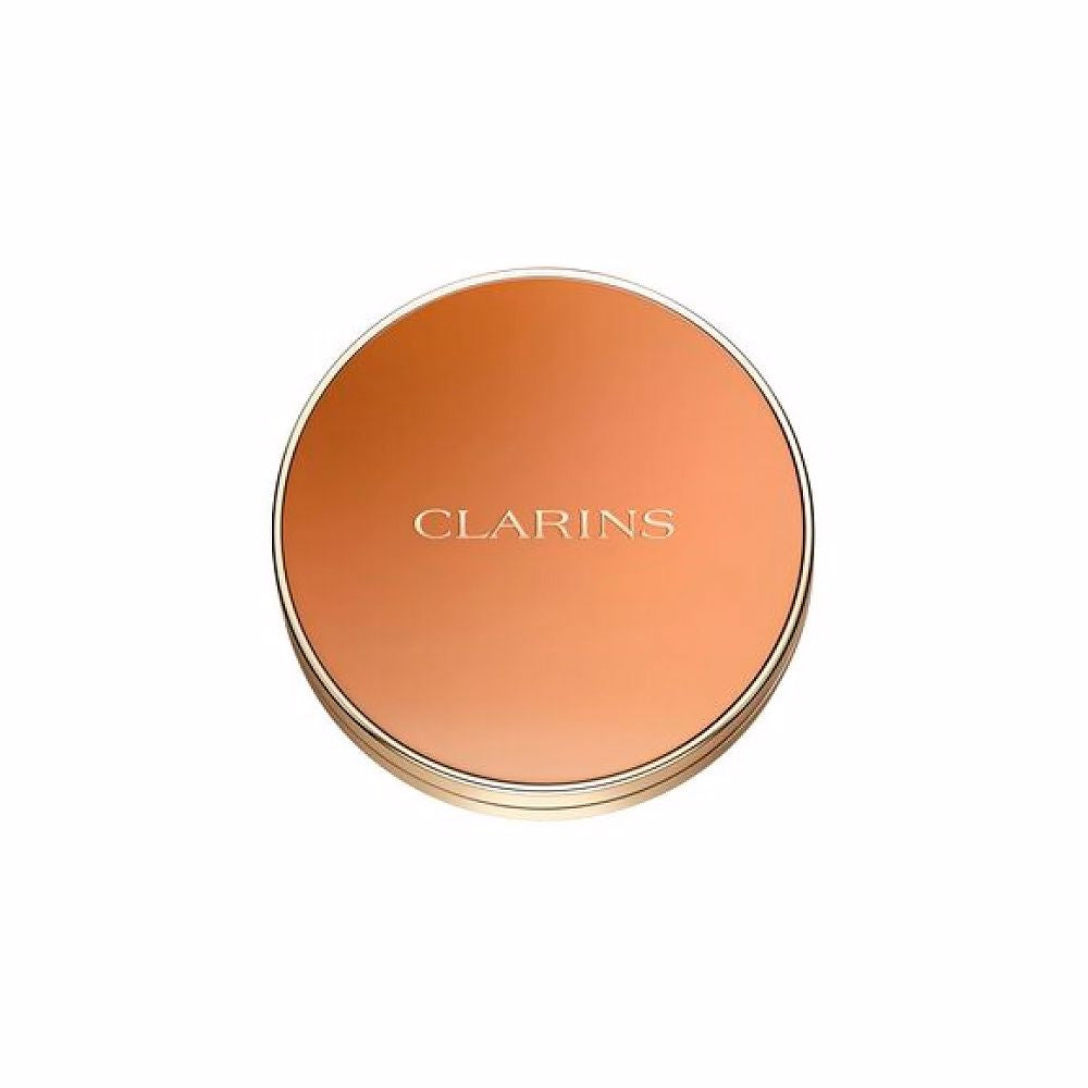 Clarins Round orange compact powder case with metallic rim, embossed brand name, minimalist metal/plastic finish