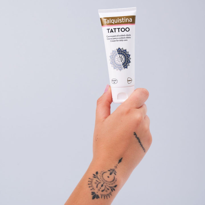 Jar of Talquistina tattoo care cream beside a tattoo sleeve, clean studio setting