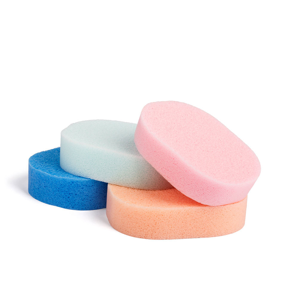 Stacked oval foam sponges in blue, light blue, pink and peach — soft textured surfaces, Suavinex