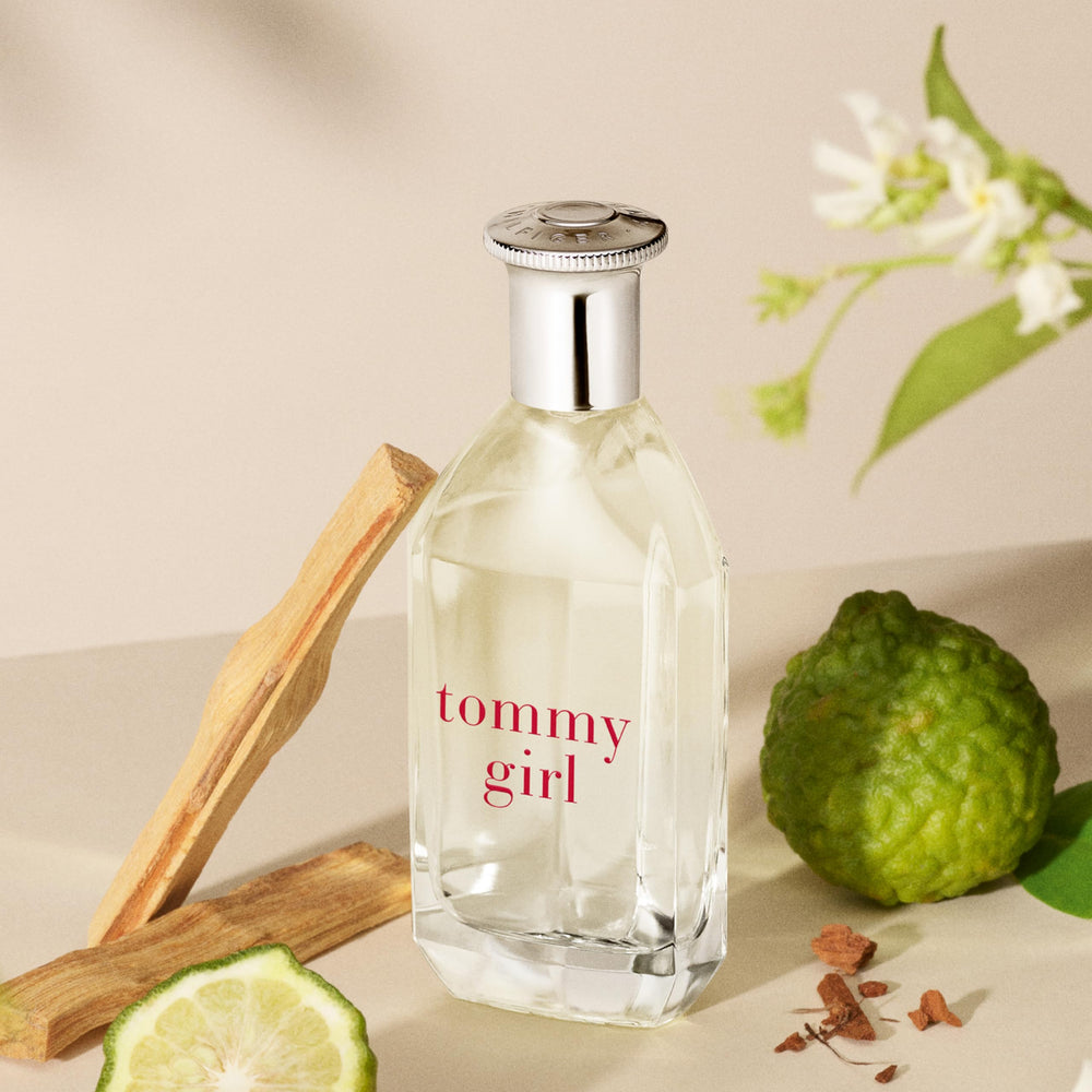 Clear curved 100 ml perfume bottle with silver cap, floral-woody scent for Women