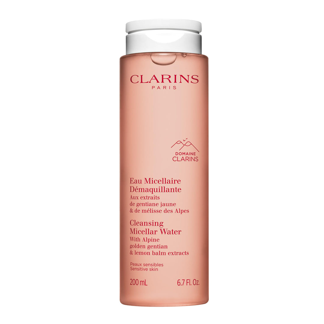 Clarins micellar cleansing water in a clear bottle beside cotton pads on white surface