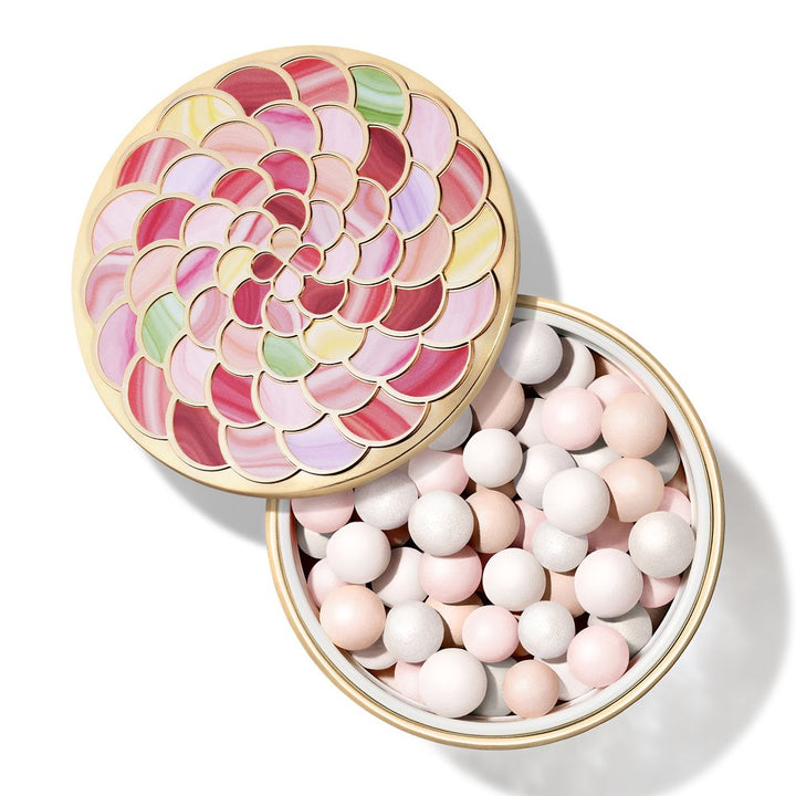 Round metal compact with gold trim holding pink, white, peach, green, yellow powder pearls and floral lid pattern by Guerlain