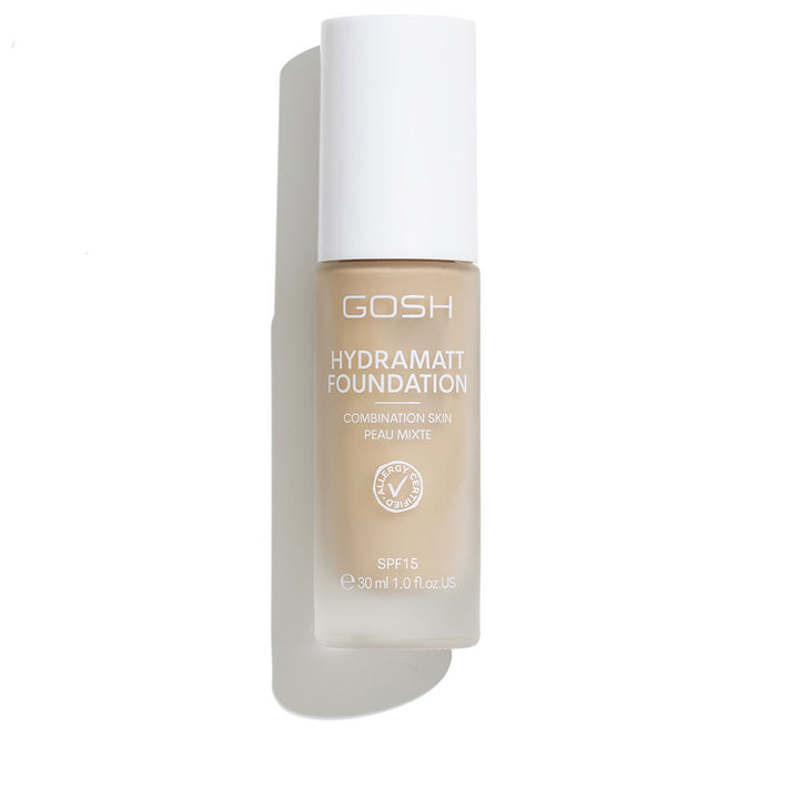 Glass cylindrical foundation bottle in beige with frosted finish, white cap and printed label — Gosh