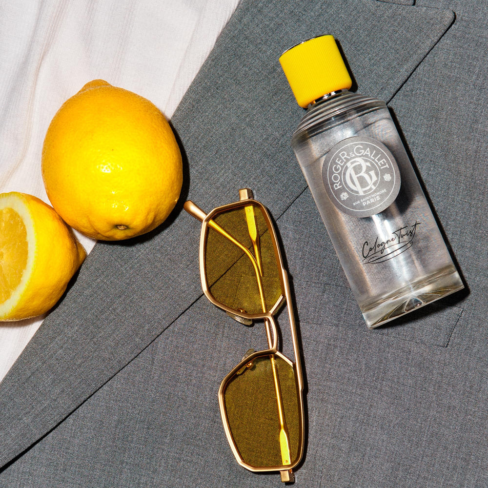 Roger & Gallet Transparent glass cologne bottle with clear yellow liquid, ribbed yellow cap, round gray label, black cursive text, presented .