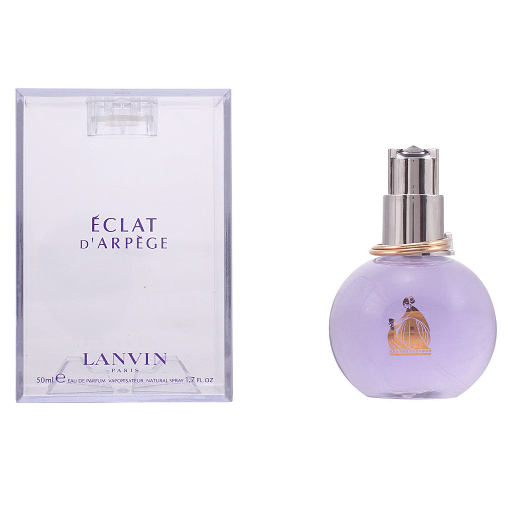 Lanvin Light purple glass round perfume bottle with silver cap, gold rings at neck, transparent box nearby.